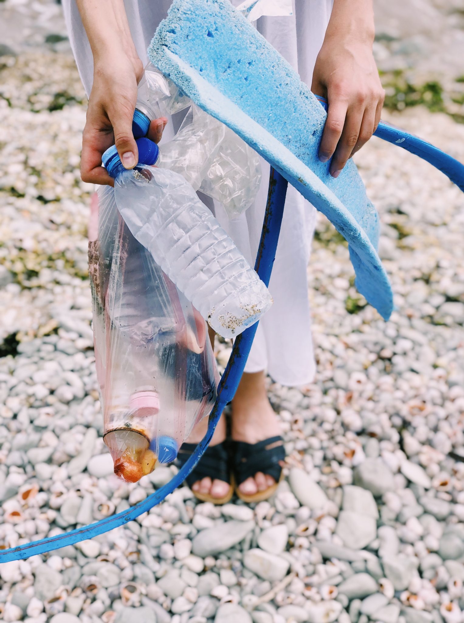 Person holding plastic bottles and hose